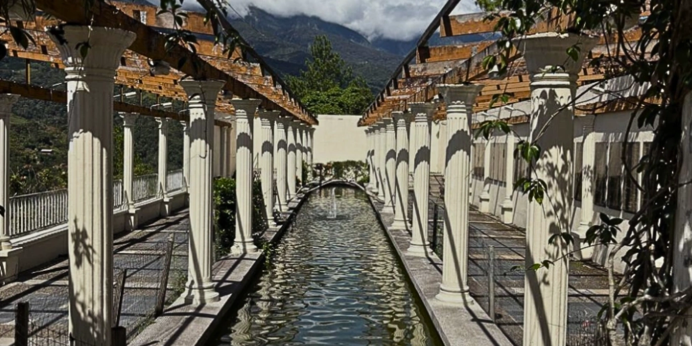 Tall white pillars standing inside Kundasang War Memorial with garden surroundings