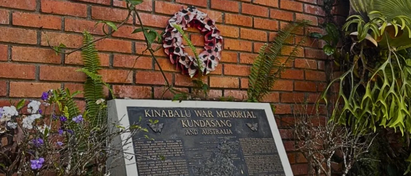 Stone monument at Kundasang War Memorial with carved historical details and inscriptions