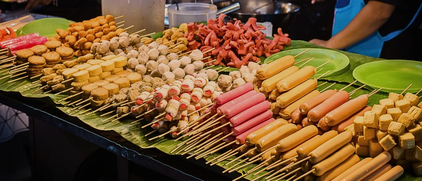 Assorted fried street food snacks in Kundasang, including sausages, fish cakes, and local treats