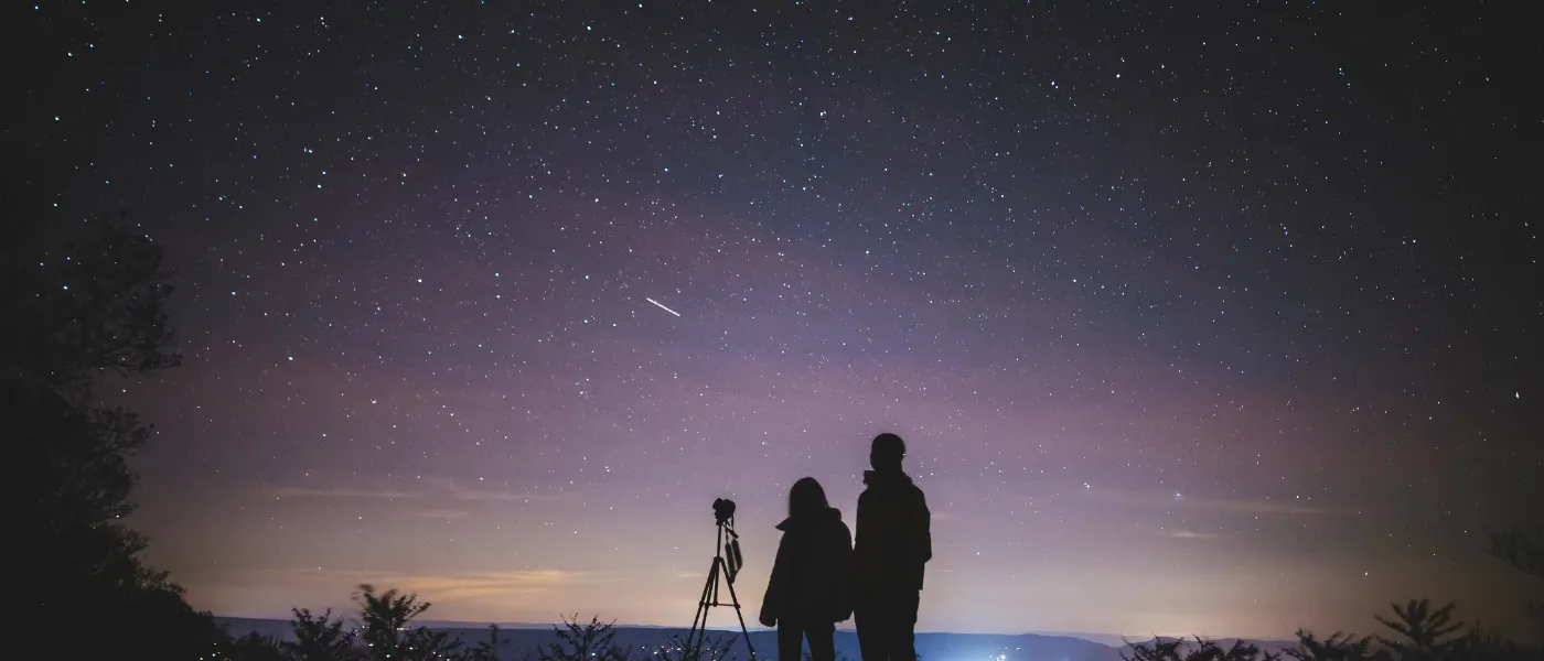 Couple stargazing under the clear, starry night sky in Kundasang.