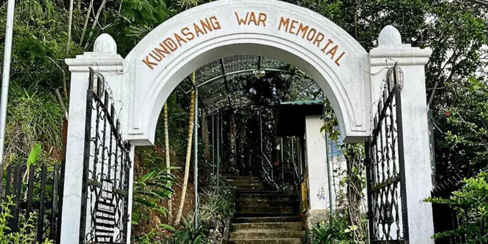 Entrance gate of Kundasang War Memorial with stone archway and commemorative design