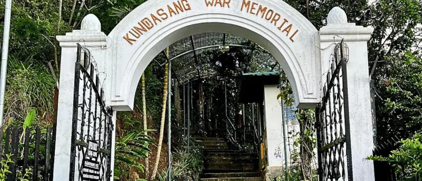 Entrance gate of Kundasang War Memorial with stone archway and commemorative design