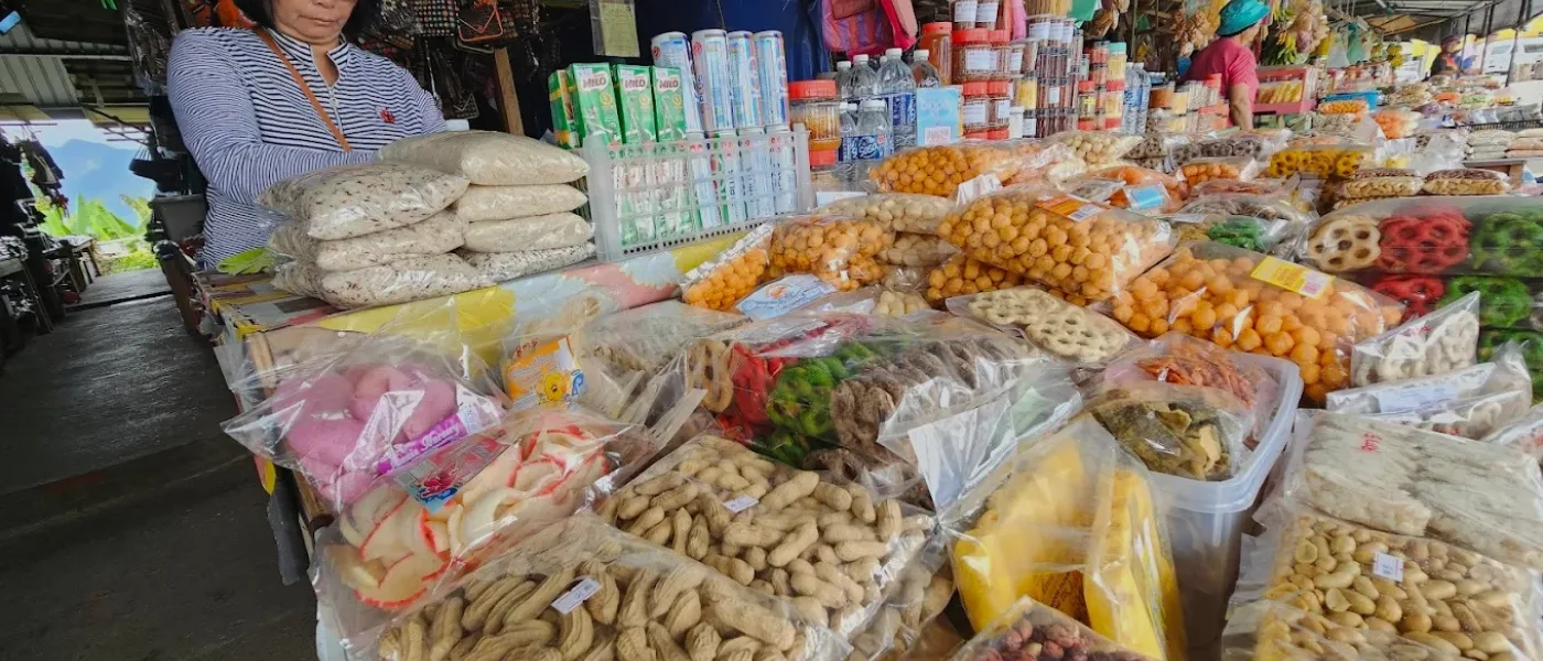 Assorted traditional snacks like amplang, kuih cincin, and local treats displayed at Pekan Nabalu Market, Kundasang