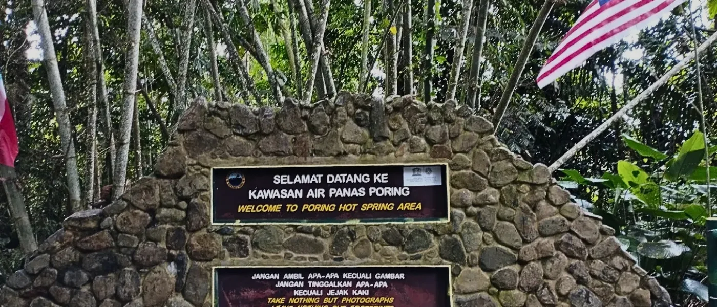 A “Welcome to Poring Hot Spring” signboard greeting visitors at the entrance of the attraction.