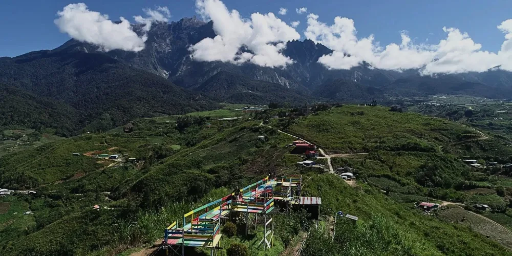 High-angle drone shot capturing the lush greenery and scenic trails of Sosodikon Hill in Kundasang