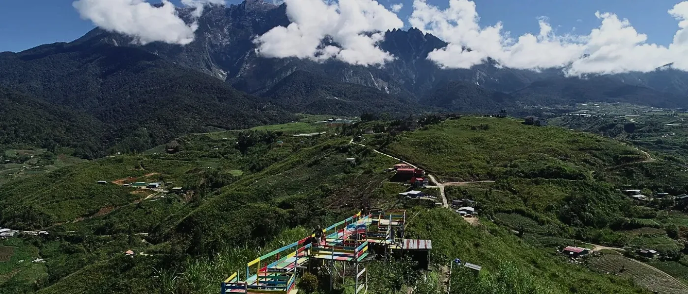 High-angle drone shot capturing the lush greenery and scenic trails of Sosodikon Hill in Kundasang
